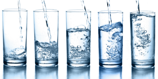 A line of glass cups that are gradually filled with more water